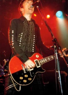 Paul performing with his iconic dual tone guitar